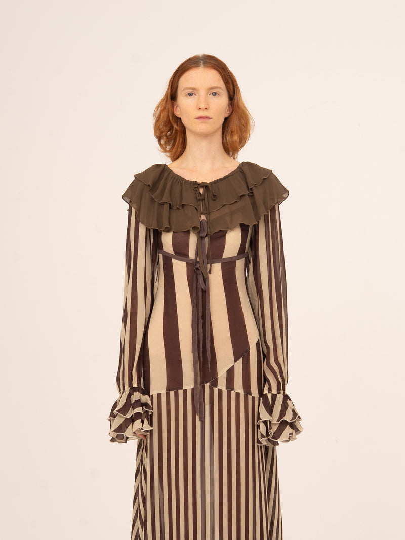 Vestido femenino estilo baby doll con estampado de rayas en tonos marrón y beige, cuello amplio con volante y mangas largas con puños fruncidos, diseño fluido y romántico ideal para looks elegantes de otoño o estilismos especiales con personalidad.