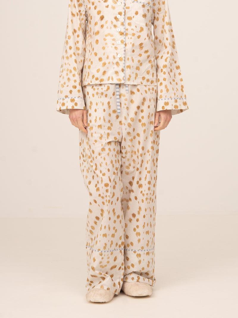 Modelo femenina vistiendo pantalón de pijama en color blanco con estampado de ciervos en tonos beige, conjunto de inspiración loungewear, fotografiado de frente sobre fondo neutro.