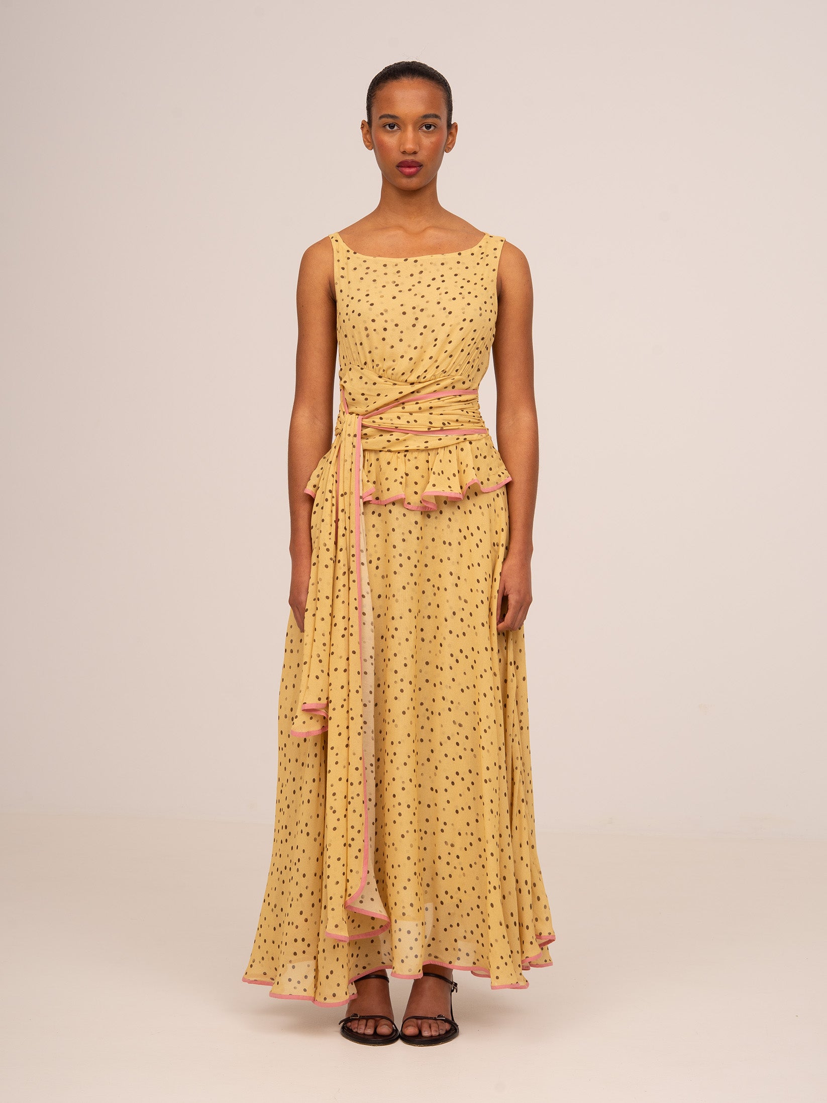 Vestido de ocasión amarillo con lunares, fluido y elegante, con detalle drapeado en la cintura perfecto para bodas o eventos especiales.