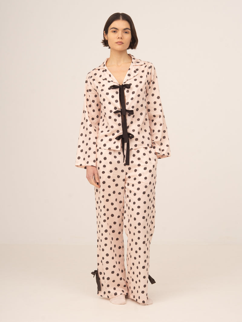 Camisa de pijama femenina de manga larga con estampado de lunares en tono nude, detalle de lazos negros en el frontal y diseño elegante y fluido, ideal para dormir o estar en casa con estilo y comodidad.