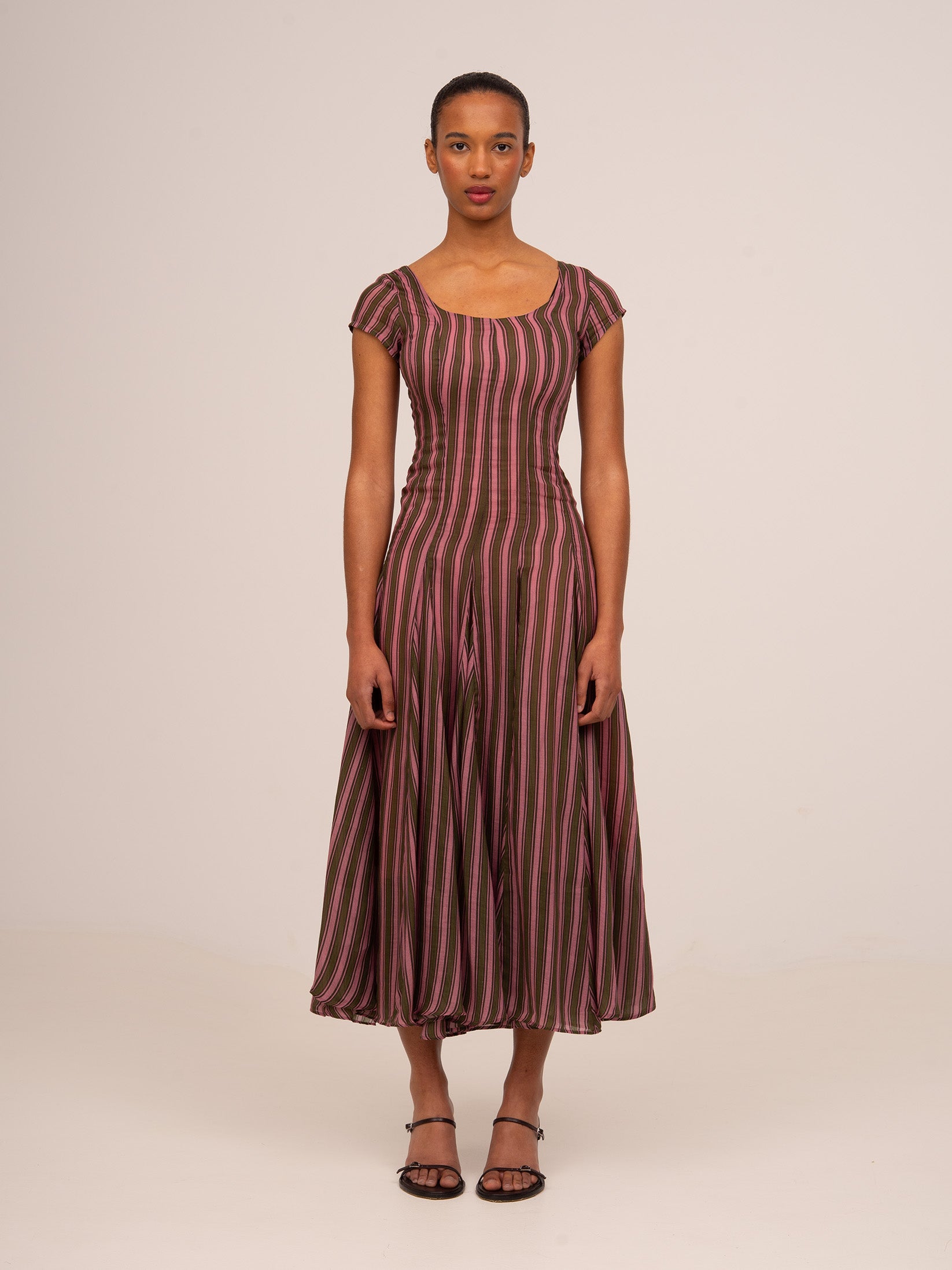 Vestido midi de mujer con estampado de rayas en tonos rosa y verde oliva, escote amplio, mangas cortas y silueta entallada con falda fluida con godets, ideal para eventos y ocasiones especiales.