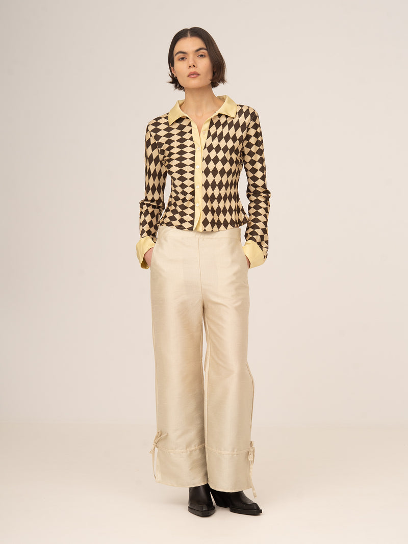 Pantalón femenino largo en color crema con acabado satinado y ligero efecto sparkle, diseño de tiro medio y pierna recta con caída fluida, elegante y sofisticado para looks de fiesta, eventos especiales o estilismos de noche.
