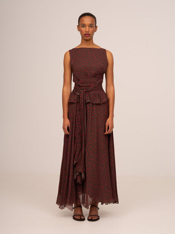 Vestido largo de mujer en color marrón con estampado de lunares rojos, diseño sin mangas y detalle drapeado en la cintura.