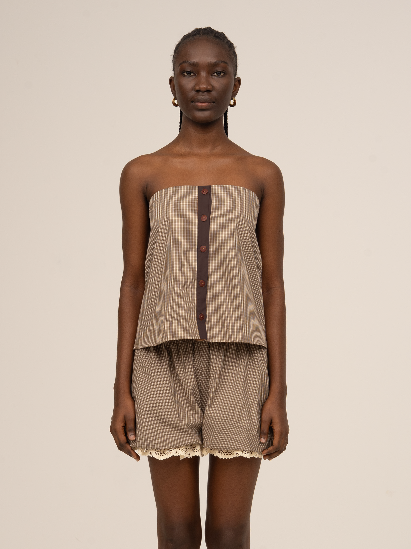 Top de cuadros marrón sin mangas para mujer con botones frontales.