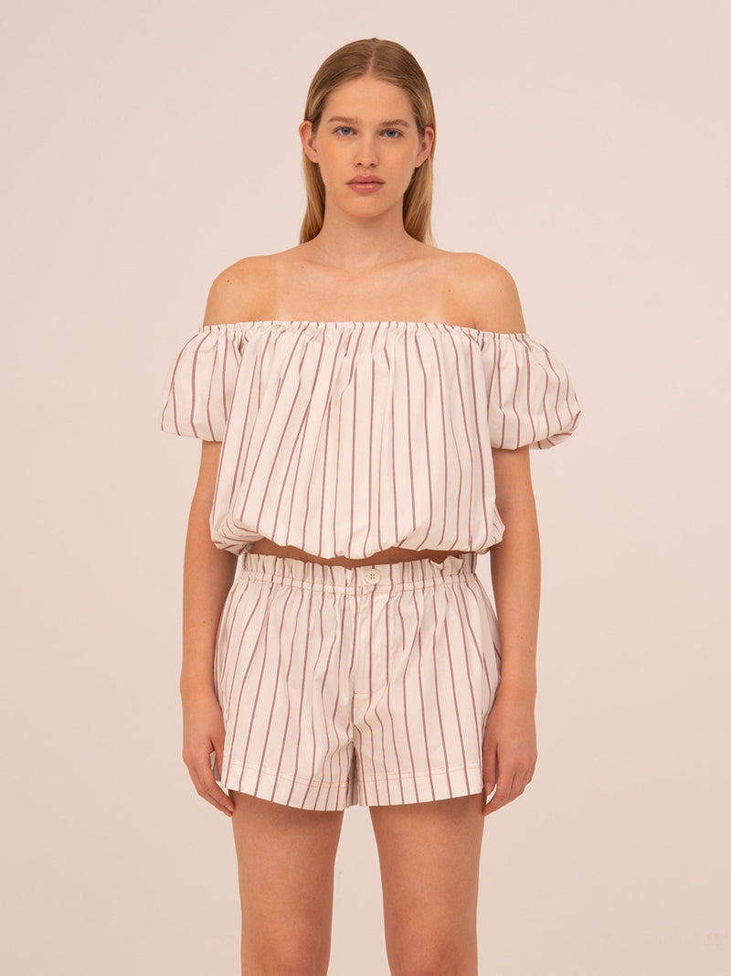 Top de rayas rojas para mujer con diseño cropped y corte abullonado. Confeccionado en tejido ligero, con escote favorecedor y estilo femenino. Un top versátil ideal para looks de verano, combinable con faldas o pantalones de tiro alto.