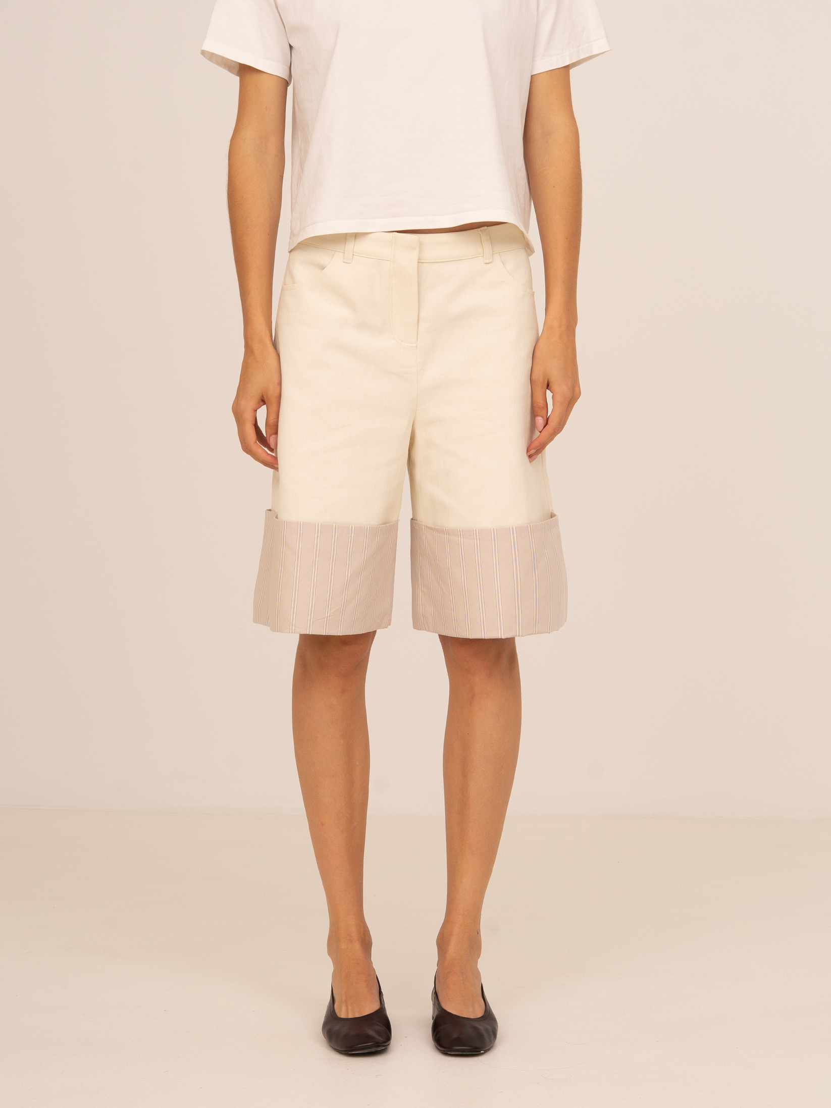 Bermudas beige de tiro medio con corte recto y detalle de bajo en tejido texturizado semitransparente. Un diseño contemporáneo y sofisticado ideal para looks minimalistas de entretiempo.