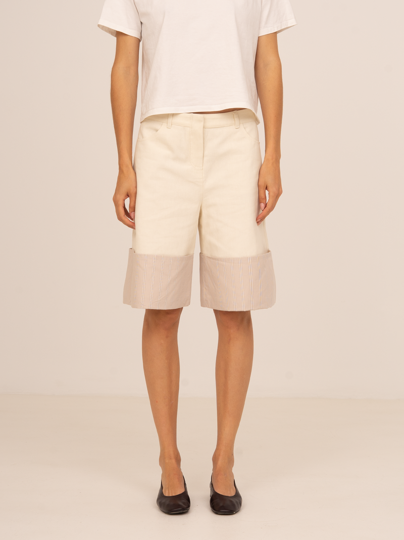 Bermudas beige de tiro medio con corte recto y detalle de bajo en tejido texturizado semitransparente. Un diseño contemporáneo y sofisticado ideal para looks minimalistas de entretiempo.