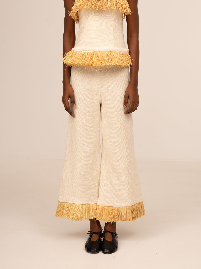 Pantalón ancho color crudo para mujer con detalle de flecos en el bajo