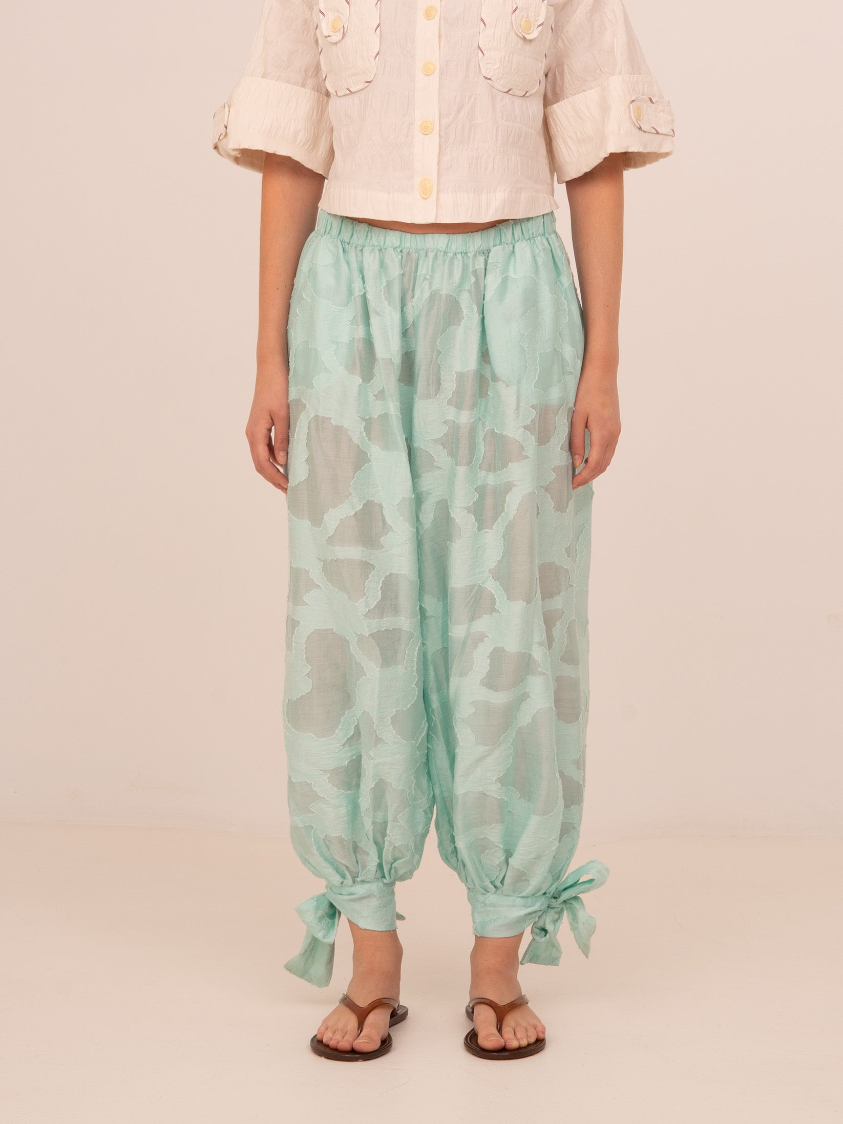 Pantalón azul de pierna ancha con diseño fluido y cintura elástica. Confeccionado en tejido ligero con detalle de lazadas ajustables en el bajo. Un pantalón cómodo y versátil ideal para looks relajados con estilo.