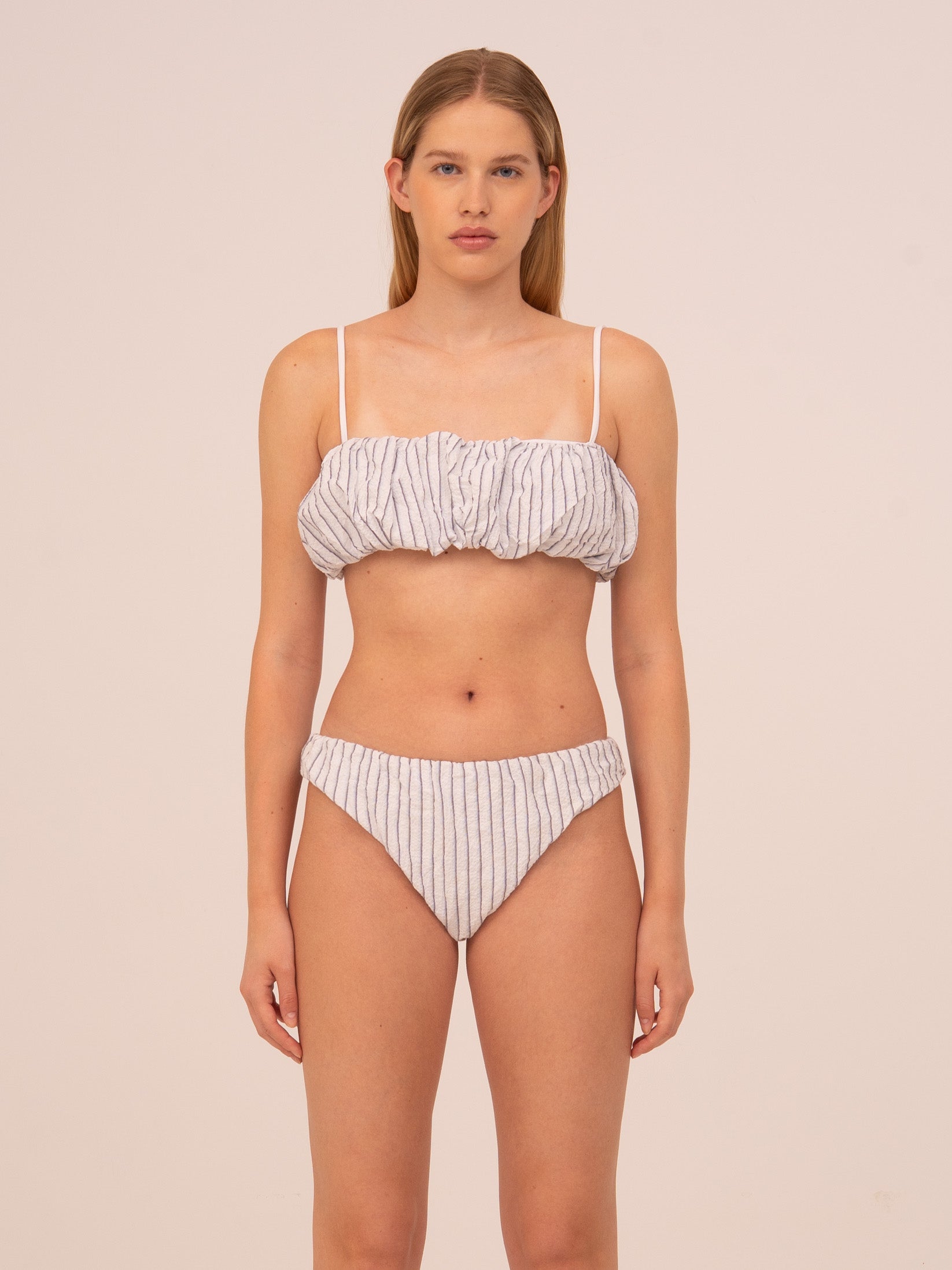 Top de bikini azul con estampado de rayas, diseño triangular femenino con tirantes ajustables. Confeccionado en tejido elástico y cómodo, ideal para combinar con la braguita a juego. Un bikini top versátil y perfecto para playa y piscina en verano.”