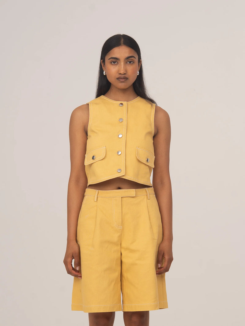 Modelo con chaleco corto de denim amarillo pálido con botones delanteros de CARMEN SAYS