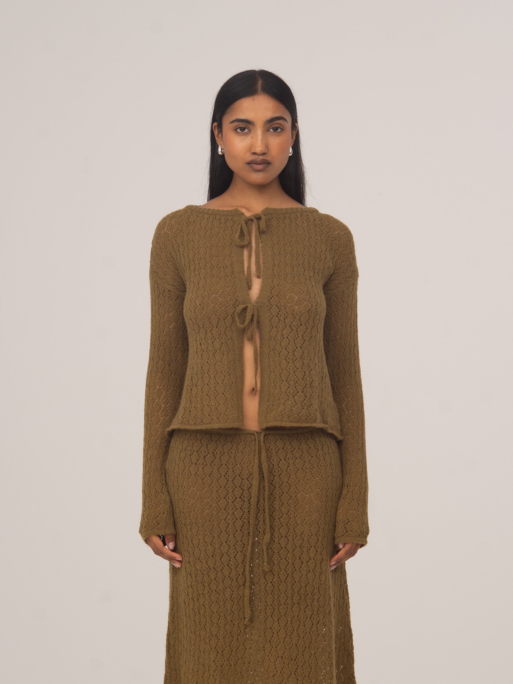 Modelo con cárdigan de punto verde Exile de CARMEN SAYS, combinado con falda midi de punto a juego