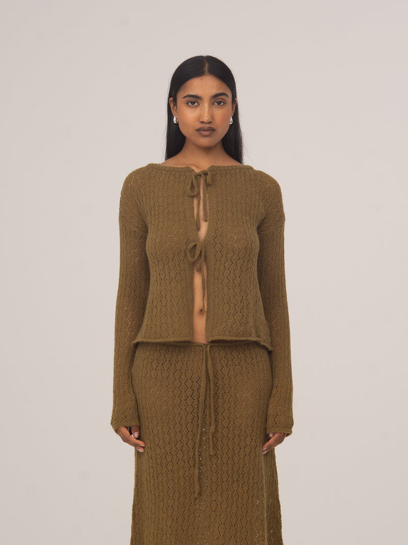 Modelo con cárdigan de punto verde Exile de CARMEN SAYS, combinado con falda midi de punto a juego