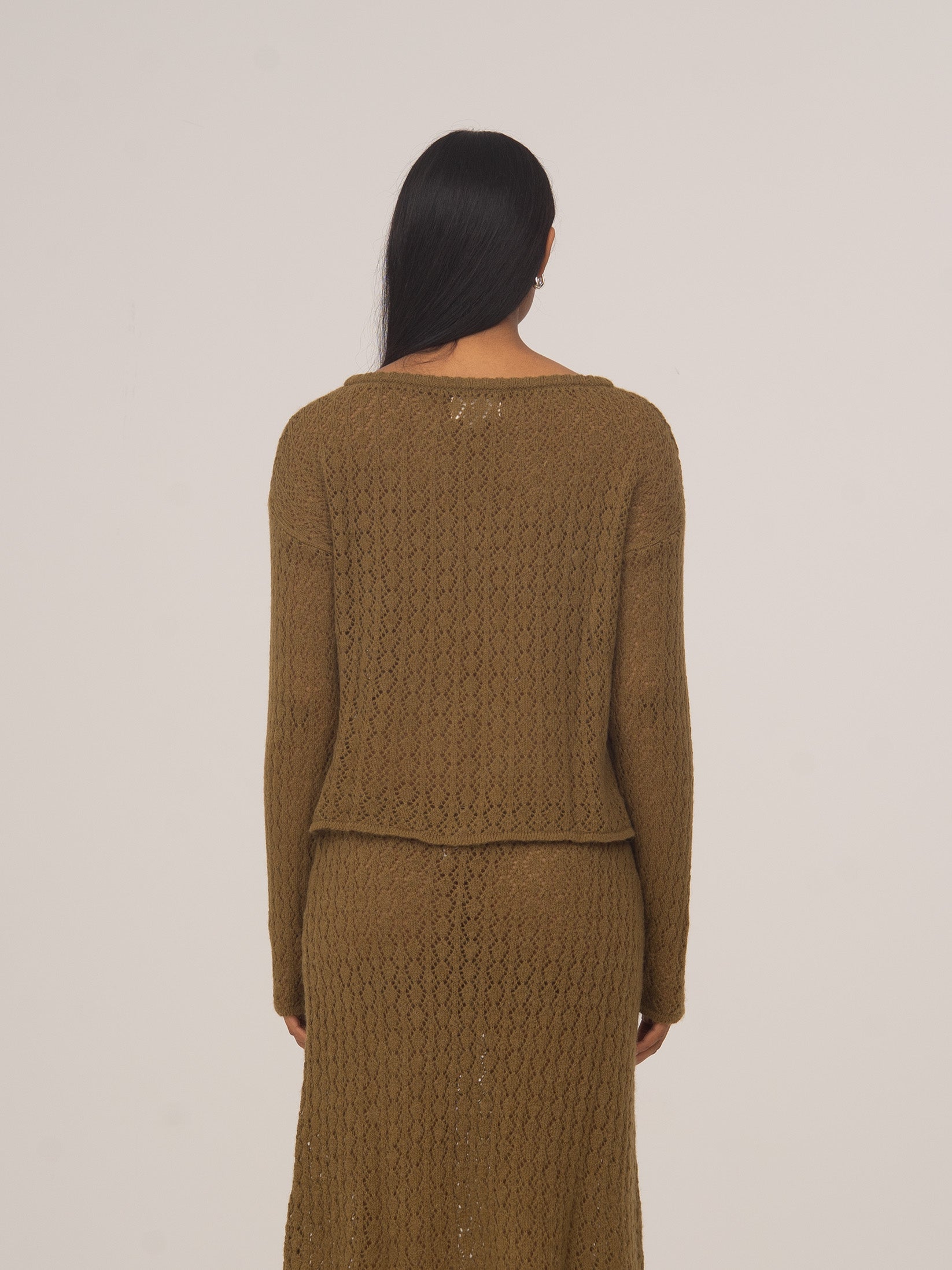 Vista trasera de modelo con cárdigan de punto verde Exile de CARMEN SAYS y falda midi a juego