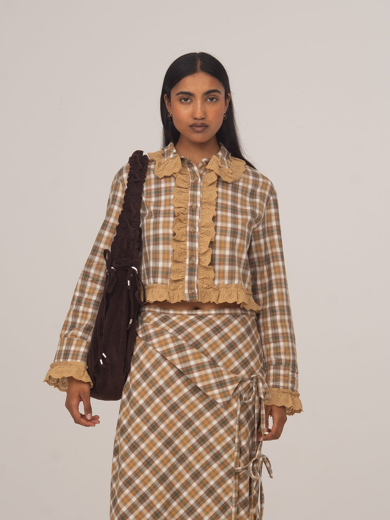 Modelo con camisa cropped de cuadros marrones Willow de CARMEN SAYS, combinada con falda midi a juego