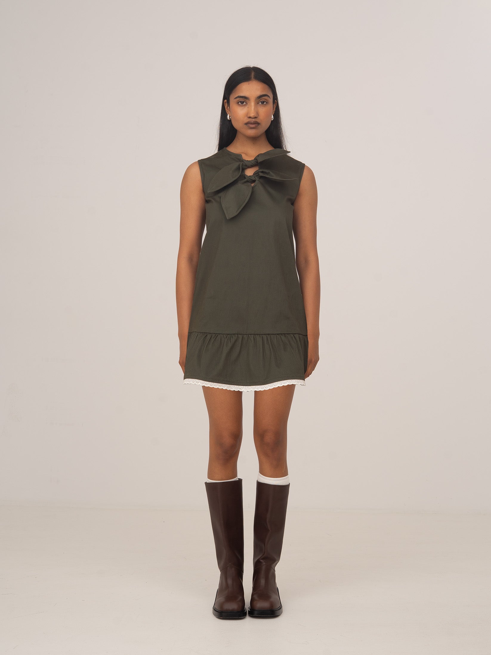 Modelo con vestido mini verde sin mangas Ivy de CARMEN SAYS, con detalle de lazada en el escote